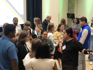 A crowd of students and alumni in an auditorium.