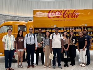 Students stand in front of a yellow 1949 Coca-Cola delivery truck.