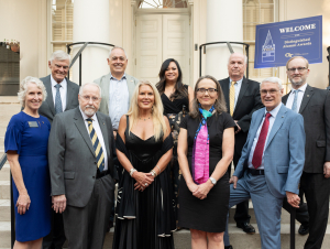 (First row, left to right): Susan Lozier, John Clark Sutherland, Kelly Sepcic Pfeil, Margaret Beier, and Rutt Bridges. (Second row, left to right): Jack McCallum, Angel Cabrera, Kristel Bayani Topping, Frank Cullen, and Nathan Meehan. A group of individuals standing on the stairs.