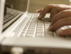 Fingers typing on a laptop keyboard