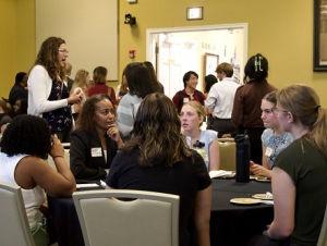 Speed networking gave students the opportunity to engage with a variety of alumni, gaining valuable insights on diverse career paths, real-world experiences, and professional development. A group of people have a discussion at a round table.