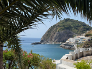 Students spent two weeks living la dolce vita in southern Italy. Beautiful view of blue water framed by green trees and stonework.